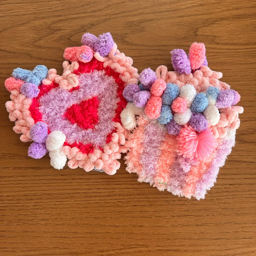 Two handmade moss coasters, one heart-themed and one designed like a unicorn cupcake, in bright, sweet colors. Set of two DIY kits by Otter's Art.