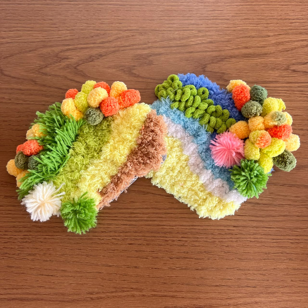 Two handmade moss coasters, one with a safari theme and one with a beach theme showing sun, sand, and sea. Set of two DIY kits by Otter's Art.