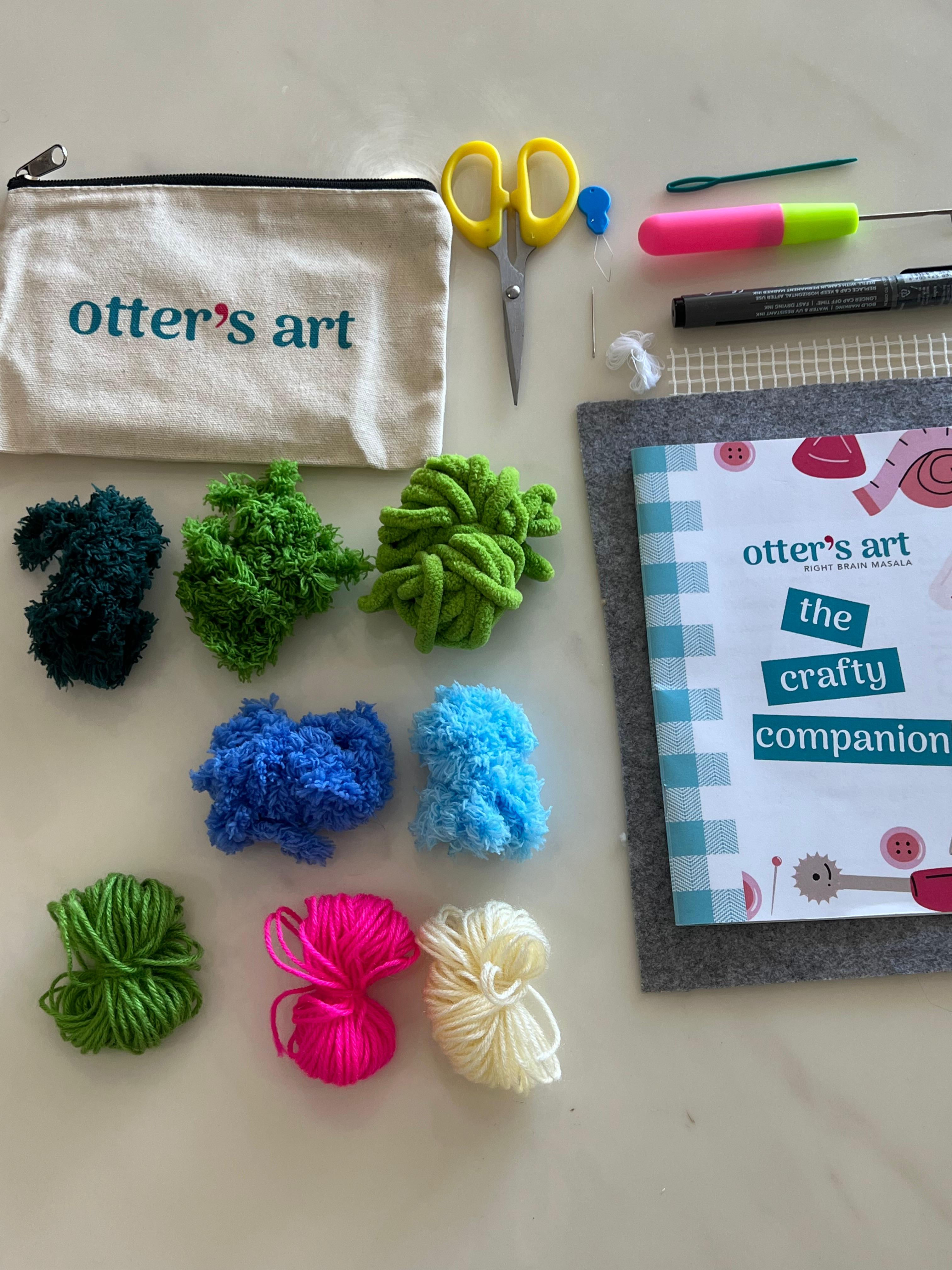 Everything you need to bring the monsoon indoors: pre-cut yarn in moss green, sky blue, cornflower blue, and pops of neon pink and cream, latch hook needle, embroidery needle, scissors, marker, mesh canvas, and your printed + video guide — all packed in an Otter's Art pouch.
