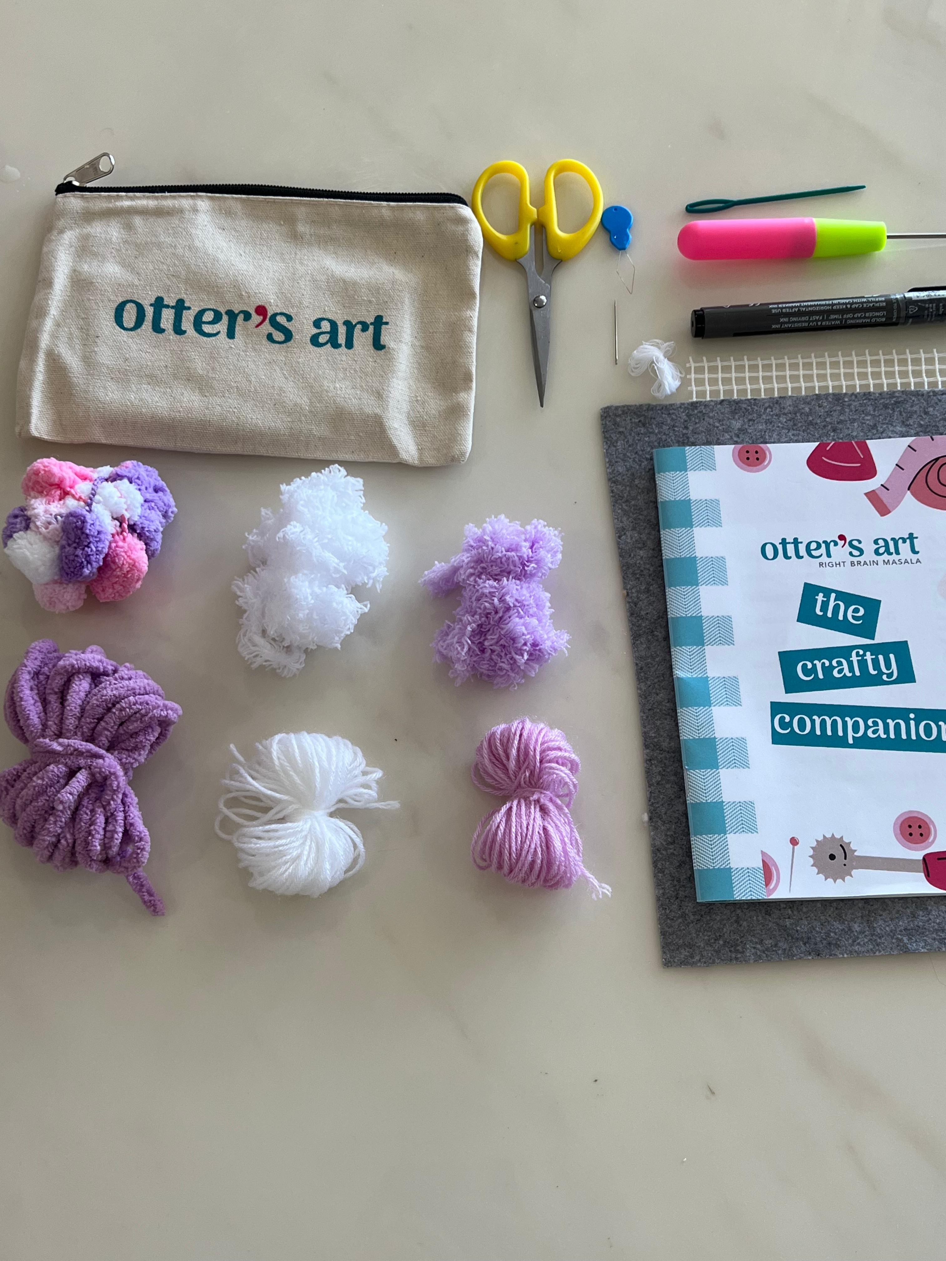 Your Taro Boba kit comes with pre-cut yarn in white, lavender, and dusty purple, a mixed pastel pom-pom pack, latch hook needle, embroidery needle, scissors, marker, mesh canvas, and the printed + video guide — all tucked into an Otter's Art pouch, ready to hook, weave, and sip in.